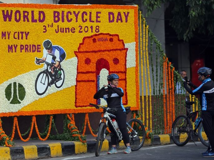 A cyclist poses for a photograph in front of an installation on World Bicycle Day in New Delhi, India, June 3, 2018. REUTERS/Amit Dave