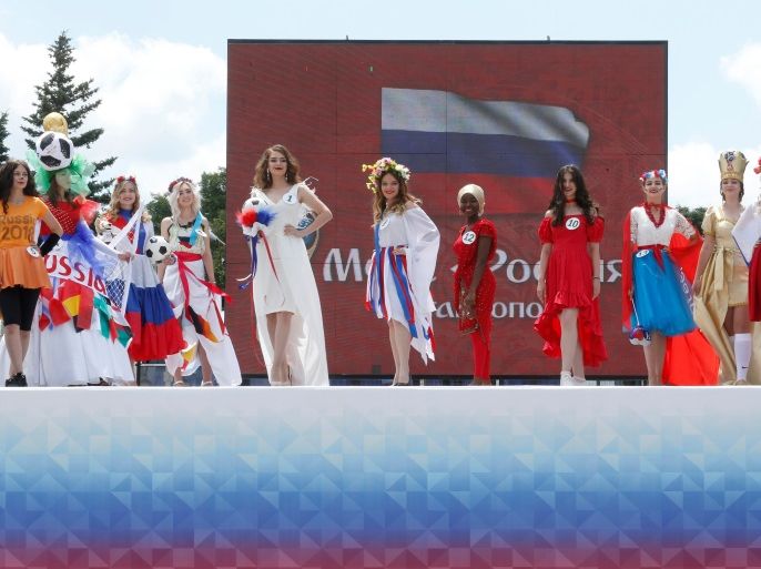 Women, dressed in costumes featuring the upcoming 2018 FIFA World Cup, take part a regional preliminary stage of the