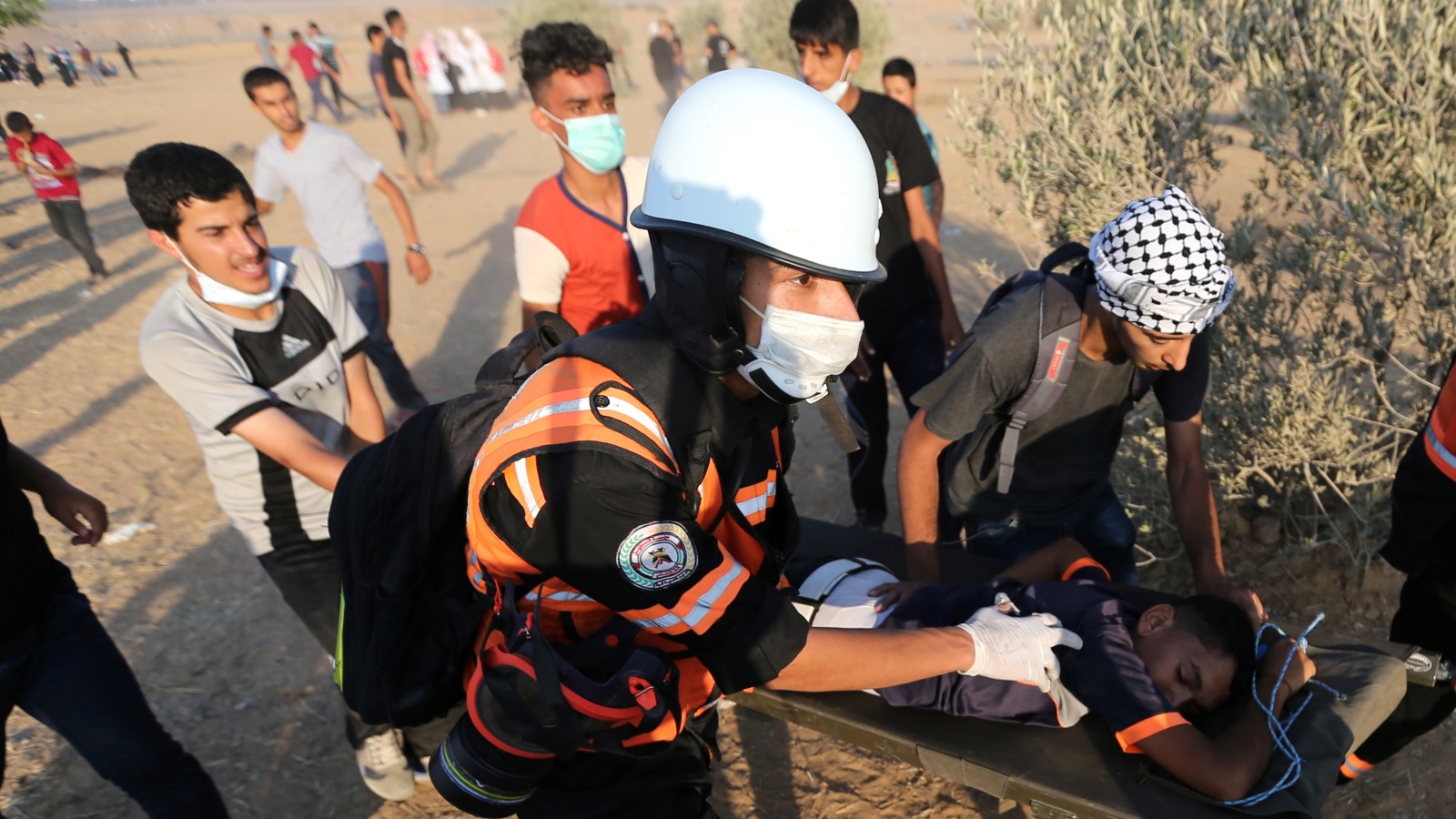 ‪إسعاف أحد المصابين عند السياج الحدودي لغزة‬ (رويترز)