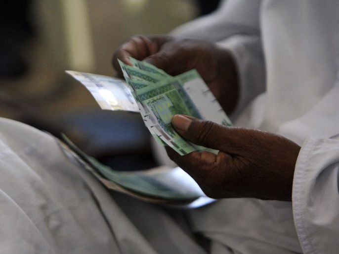 A man counts notes after receiving the new Sudanese currency at a central bank branch in Khartoum July 24, 2011. Sudan on Sunday started circulating its new currency, the central bank said, days after South Sudan started rolling out a currency of its own. REUTERS/ Mohamed Nureldin Abdallah (Sudan - Tags: POLITICS BUSINESS)