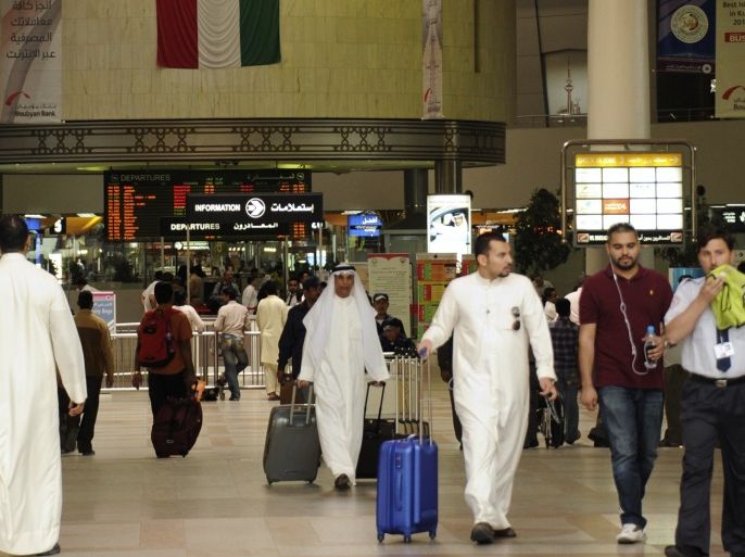 Passengers walk under the flight schedule board showing several cancelled flights, in Kuwait International Airport October 24, 2011. About 4,000 workers at state-owned carrier Kuwait Airways have gone on strike demanding higher wages, a source familiar with the matter said on Monday, in the latest labour dispute to hit the country. The airline, which is seeking investors to buy a $280 million stake to privatise the carrier, has so far cancelled several flights to Gulf