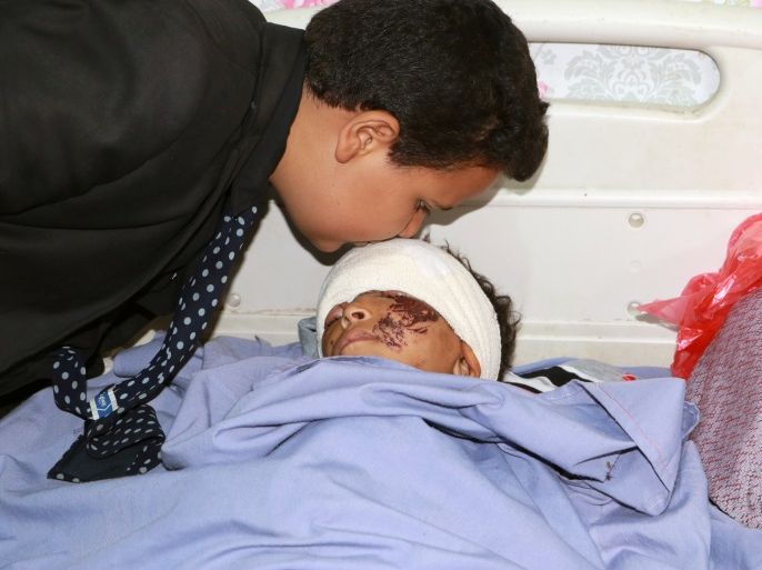 ATTENTION EDITORS - VISUAL COVERAGE OF SCENES OF INJURY OR DEATH A member of the Children Parliament kisses boy injured in Thursday's air strike, in a hospital in Saada, Yemen August 11, 2018. REUTERS/Naif Rahma