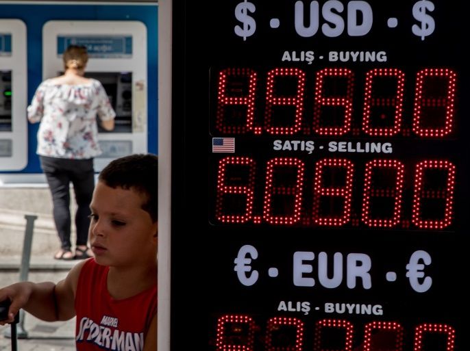 ISTANBUL, TURKEY - AUGUST 02: A boy stands next to a currency exchange sign on August 2, 2018 in Istanbul, Turkey. The Turkish Lira dropped to a record low passing 5 TL to the dollar after the United States imposed sanctions on Turkey's justice and interior ministers over the trial of U.S Pastor Andrew Brunson. The move threatens to push already tense relations between the two countries into crisis. (Photo by Chris McGrath/Getty Images)