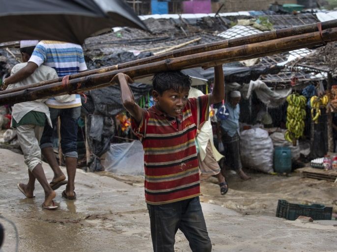 UNCHIPRANG, BANGLADESH - AUGUST 28: A Rohingya boy carries wood through a market August 28, 2018 in Unchiprang refugee camp, Cox's Bazar, Bangladesh. UN investigators said on Monday that Myanmar's army had carried out genocide against the Rohingya in Rakhine state and that its top military figures must be investigated for crimes against minorities across the country. The UN report accused Myanmar's military for murders, imprisonments, enforced disappearances, torture