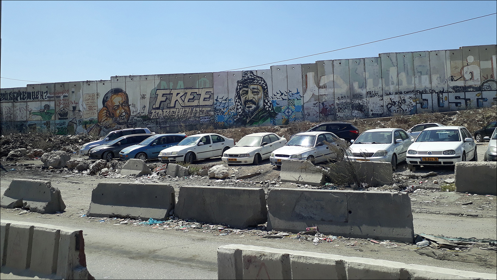 فنانون فلسطينيون وعالميون خطوا لوحات مختلفة على الجدار العازل (الجزيرة)