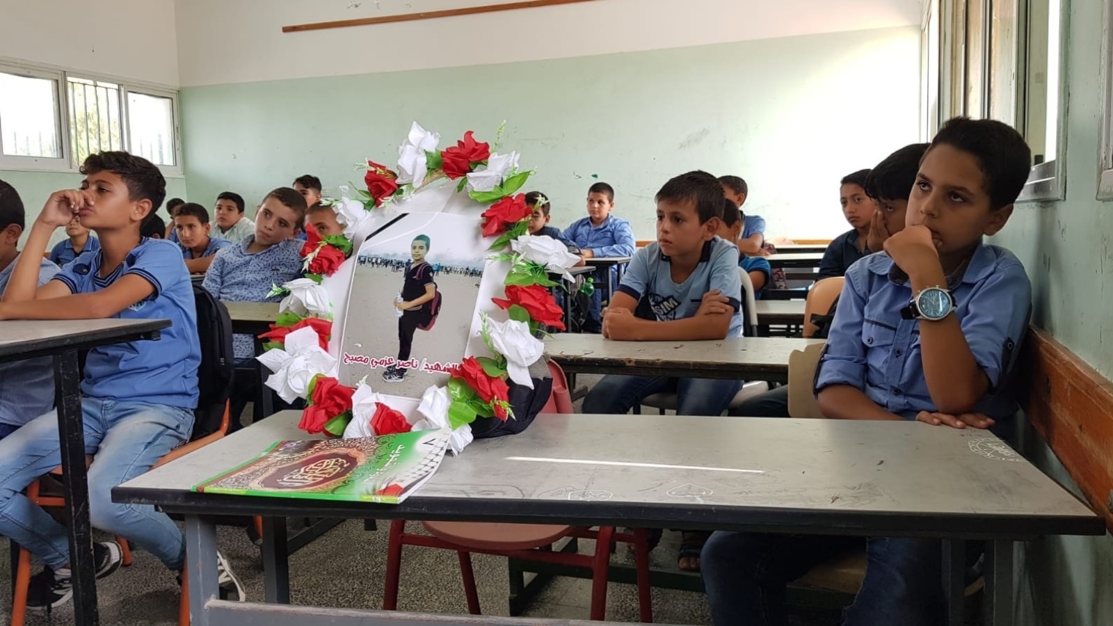 ‪صورة مزينة بالورود وضعها زملاء الشهيد في مدرسته بخان يونس‬ (الجزيرة نت)