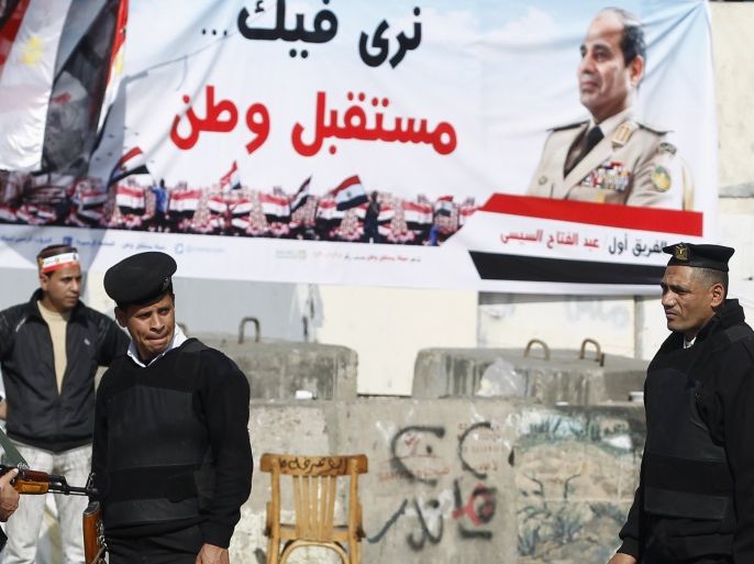 Police officers stand guard in front of banners supporting Egypt's army chief General Abdel Fatah al-Sisi during celebrations of the third anniversary of Egypt's uprising at El-Thadiya presidential palace in Cairo January 25, 2014. Egyptian police fired live rounds in the air to disperse about 1,000 anti-government protesters in central Cairo on Saturday, a Reuters witness said, amid fears of violence on the anniversary of the 2011 revolt that ousted autocrat Hosni Mubarak. REUTERS/Amr Abdallah Dalsh (EGYPT - Tags: POLITICS CIVIL UNREST ANNIVERSARY MILITARY)