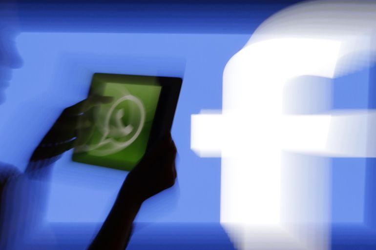 A woman holds a tablet displaying WhatsApp's logo in front of the screen with the Facebook logo in this photo illustration taken in Prague February 20, 2014. Facebook Inc's purchase of fast-growing mobile-messaging start-up WhatsApp for $19 billion (11 billion pounds) stunned the markets but analysts said the deal made strategic sense as it will solidify the social network's position as a leader in mobile. Picture taken with a zoom burst. REUTERS/David W Cerny (CZECH REPUBLIC - Tags: BUSINESS LOGO SCIENCE TECHNOLOGY BUSINESS TELECOMS)