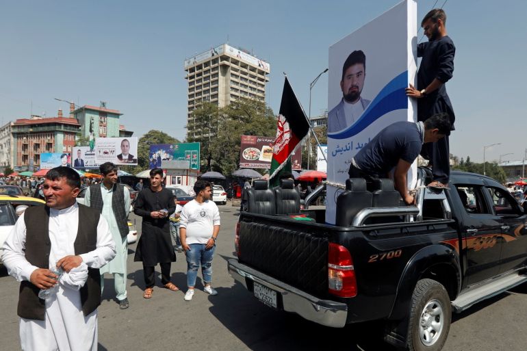 People hold a poster of a parliamentary candidate on the back of a truck during the first day of election campaign in Kabul, Afghanistan September 28, 2018. Picture taken September 28, 2018. REUTERS/Omar Sobhani