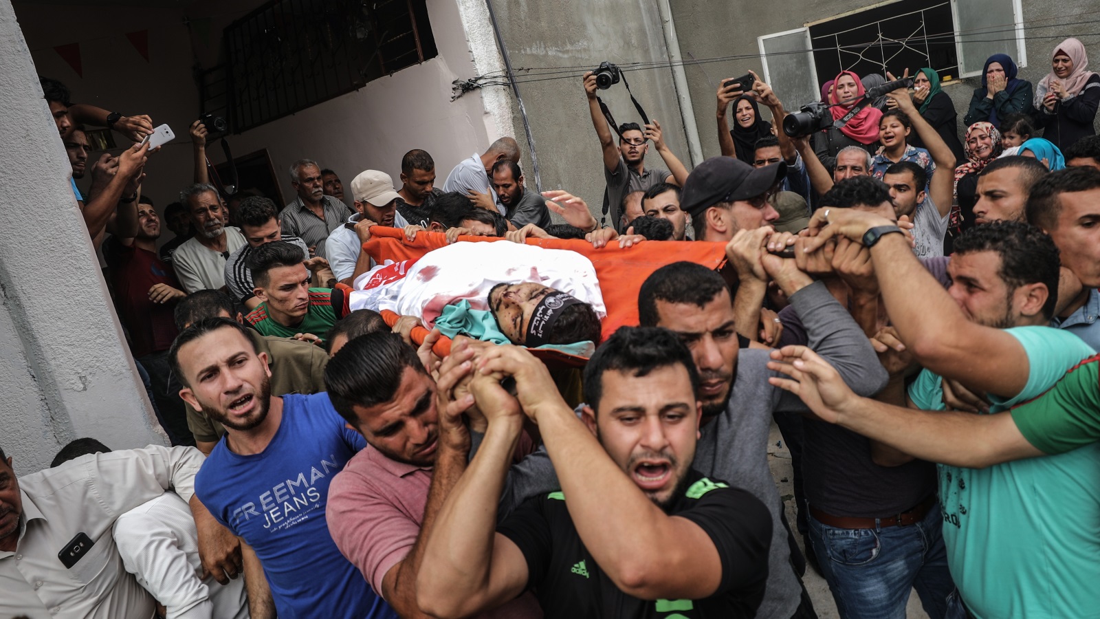 ‪فلسطينيون يشيعون الشاب ناجي الزعانين الذي استشهد في الغارات الإسرائيلية‬ (الأناضول)