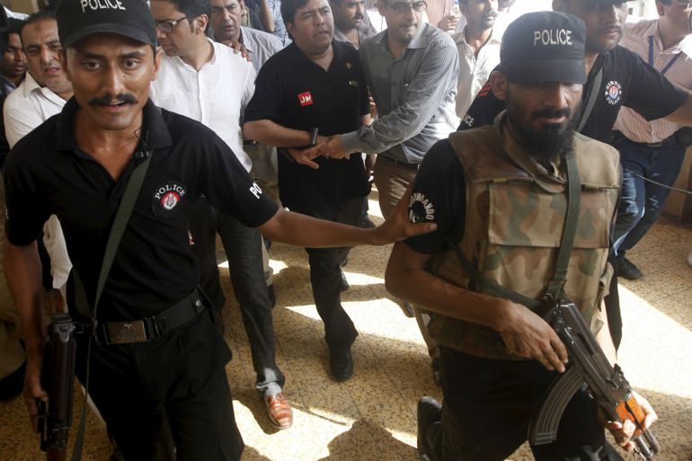 Police and Federal Investigation Agency (FIA) officials escort Shoaib Shaikh (C), CEO of Axact, a Pakistani software company, after he was produced before a district court in Karachi, Pakistan