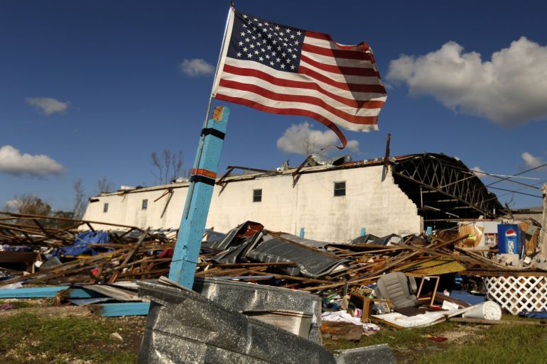 A U.S. flag flies in front of a building damaged by Hurricane Michael in Panama City, Florida, U.S. October 11, 2018. REUTERS/Jonathan Bachman