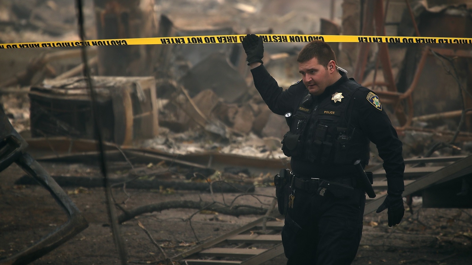 شرطي يعاين موقعا ببلدة براديس في كاليفورنيا دمرته الحرائق (الفرنسية)