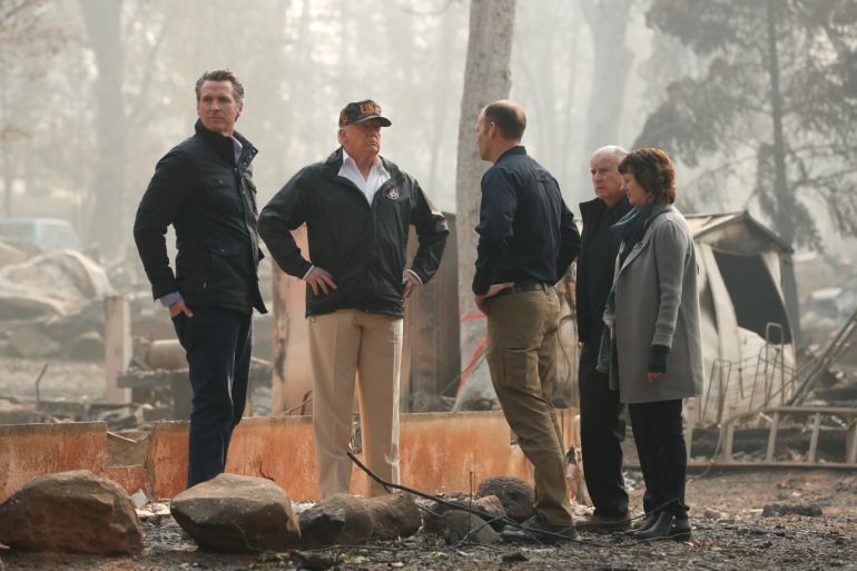 U.S. President Donald Trump visits the charred wreckage of Skyway Villa Mobile Home and RV Park with Governor-elect Gavin Newsom (L), FEMA head Brock Long (3rd R), Paradise Mayor Jody Jones (R) and Governor Jerry Brown in Paradise, California, U.S., November 17, 2018. REUTERS/Leah Millis