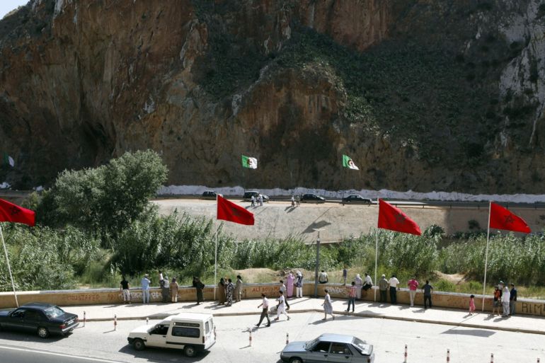 People stand near a border post on the Algerian side of the Morocco-Algeria border in the north east of Morocco July 31, 2011. Morocco's King Mohammed renewed calls on Saturday to normalise ties and reopen borders with wealthier neighbour Algeria, saying that Rabat wants to build an integrated North African economic bloc. Morocco closed the border following a 1994 Islamist militant attack in Marrakesh, which it blamed on Algeria's secret service, and the border region remains tense. REUTERS/Youssef Boudlal (MOROCCO - Tags: POLITICS)