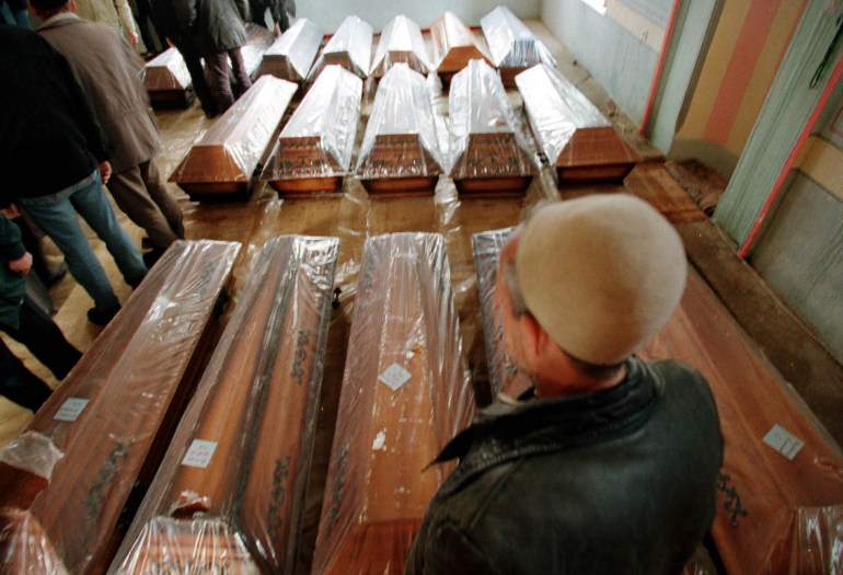 A relative of the 45 ethnic Albanian civilians allegedly massacred by Serb forces at Racak looks at the coffins of the victims in Racak's mosque February 10. The bodies finally returned home on Wednesday, after three weeks of forensic examination and wrangling between relatives and Serbian authorities.