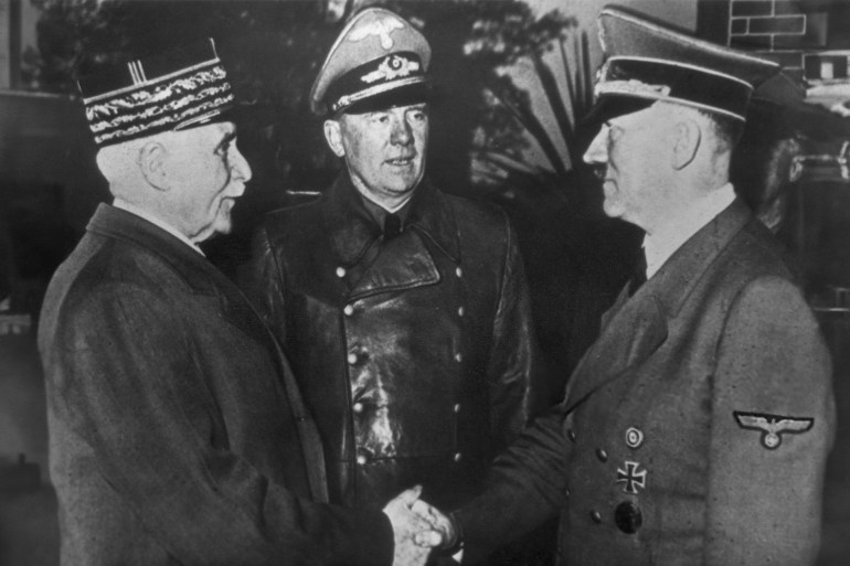 French Marshal and Vichy leader Henri-Philippe Petain (1856 - 1951, left) and Nazi leader Adolf Hitler (1889 - 1945, right) share the famous 'handshake at Montoire' while interpreter Colonel Schmidt watches, October 1940. Thus Petain announces officially that Vichy-France is prepared to collaborate with the German Reich. (Photo by Hulton Archive/Getty Images)