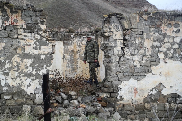An Azeri service member walks in the area, which came under the control of Azerbaijan's troops following a military conflict over Nagorno-Karabakh against ethnic Armenian forces and a further signing of a ceasefire deal, in Jabrayil District, December 7, 2020. Picture taken December 7, 2020. REUTERS/Aziz Karimov