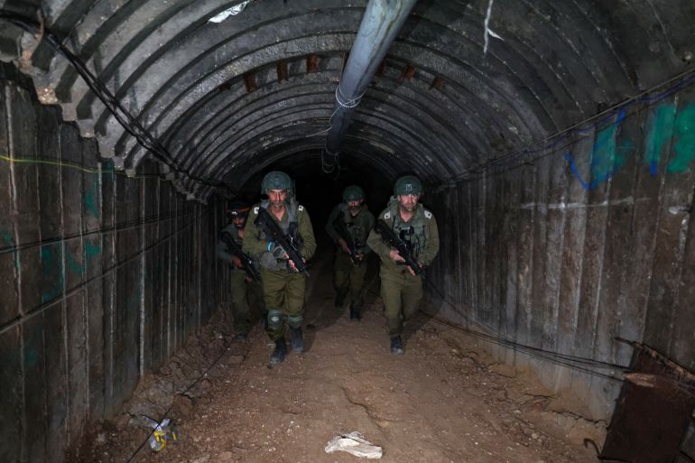 In this picture taken during a media tour organised by the Israeli military on December 15, 2023, soldiers visit a tunnel that Hamas reportedly used to attack Israel through the Erez border crossing on October 7. - The Israeli army said on December 17, 2023 it had uncovered the biggest Hamas tunnel in the Gaza Strip so far, just a few hundred metres from the Erez border crossing. (Photo by JACK GUEZ / AFP)
