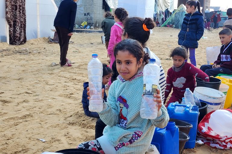 طفلة فلسطينية تنتظر دورها لتعبئة عبوات بلاستيكية بالمياه في مدينة رفح جنوب قطاع غزة-رائد موسى-رفح-الجزيرة نت