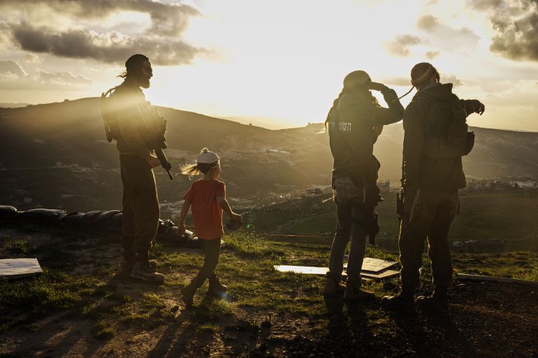 YITZHAR, OCCUPIED WEST BANK -- FEBRUARY 6, 2024: Tuvia levy 26, from left, Yosef, 5, Yishai Sheinman, 27 and Marom Harel, 25, look on at nearby Palestinian towns from their security outpost in Yitzhar, Occupied West Bank , Tuesday, Feb. 6, 2024. 27-year-old Yishai Sheinman, has been at work establishing illegal outposts of a nearby hilltop settlement, known as Yitzhar. For a long time, Israeli soldiers were tasked with stopping the expansion of settlements, which much of the world, including the United States, view as a illegal under international law. Soldiers sometimes clashed with Yishai, who belongs to an extremist group called the Hilltop Youth, with security forces regularly tearing down homes that the Hilltop Youth tried to construct on land claimed by Palestinians, and intervening when their attempts at antagonizing their Palestinian neighbors turned violent. (MARCUS YAM / LOS ANGELES TIMES)