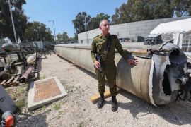 المتحدث العسكري الإسرائيلي دانيال هاغاري يقف بجوار صاروخ باليستي إيراني سقط في جنوب إسرائيل (الفرنسية)