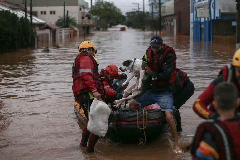 BRAZIL-ENVIRONMENT-WEATHER-FLOOD Firefighters rescue a man and his dog from a flooded area at the city center of Sao Sebastiao do Cai, Rio Grande do Sul state, Brazil on May 2, 2024. The death toll from a severe storm in Rio Grande do Sul, in southern Brazil, rose to 13, amid the "worst disaster" in the history of the state where President Luiz Inacio Lula da Silva traveled on Thursday. (Photo by Anselmo Cunha / AFP) DATE 02/05/2024 SIZE x Country BRA SOURCE AFP/ANSELMO CUNHA