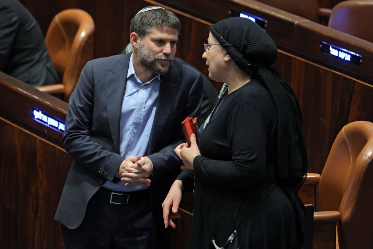 Israeli Knesset (Israeli parliament) member Bezalel Smotrich (L), leader of the Religious Zionist Party, speaks with his colleague and party member Orit Strook (R) during a session elect the new speaker of the assembly at its Plenum Hall in Jerusalem on December 13, 2022. (Photo by Gil COHEN-MAGEN / AFP)