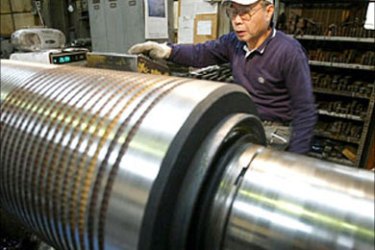 Japanese worker turns steel on lathe at steel factory Tokyo Japan