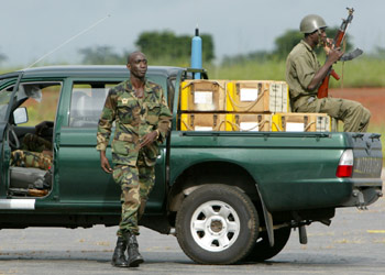An Ivory Coast army soldier sits on a pick-up truck with ammuniton at Yamoussoukro airport, October 7, 2002. Ivory Coast's army advanced with a barrage of heavy gunfire into the outskirts of the rebel stronghold of Bouake as West African mediation efforts collapsed. REUTERS/Ruben Sprich REUTERS