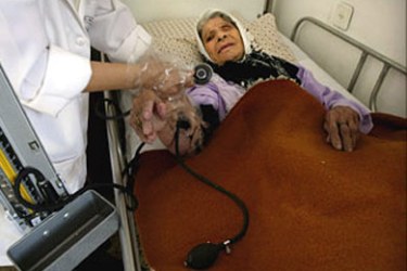 An elderly Palestinian woman receives medical treatment at the El Wafa Elderly Nursing Home run by the El Wafa