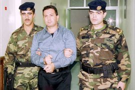 Jordanian soldiers escort Majed Shamayleh, the prime suspect in a bank loans scandal, on his arrival at Amman airport November 19, 2002. Shamayleh was extradited from Australia and taken to a state security court for interrogation. REUTERS/Petra