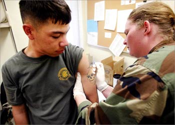 U.S. Marine Lance Corporal Keith Russell (L), from the 1st Force Service Support Group, receives his smallpox vaccination from HS2 Laura Bicking, of the U.S. Navy, during inoculations at Camp Pendleton January 31, 2003. One of the last things soldiers do before being deployed, is receive their innoculations. REUTERS/Mike Blake