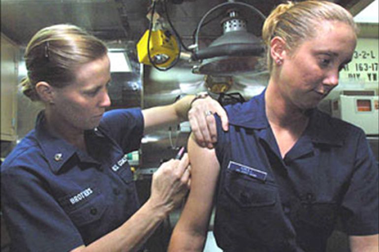 U.S. Coast Guard seaman Charity Knoll (R) is given an anthrax
