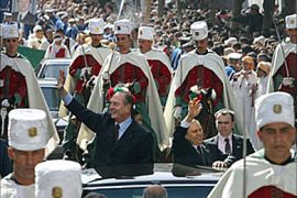 r_French President Jacques Chirac (L) and Algerian President Abdelaziz Bouteflika surrounded by the Republican guard wave to the crowd upon their arrival in Algiers