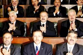 Deputies applaud Turkey's ruling party Justice and Development Party leader Tayyip Erdogan (bottom C) sitting next to Prime Minister Abdulllah Gul ( bottom R), in Ankara March 11, 2003. Erdogan is set to take oath in parliament as a deputy and his party ally is due to step down to lead the way to Erdogan to become Turkey's next prime minister. REUTERS/Fatih Saribas