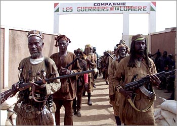 Young members of a special unit of the MPCI rebel movement called "Warriors of the light" train in Bouake, Ivory Coast, March 6, 2003. The unit is composed by 1,000 young soldiers, most of them Dozos, traditionnal hunters from the north of the country, known for their magical power. REUTERS /Luc Gnago
