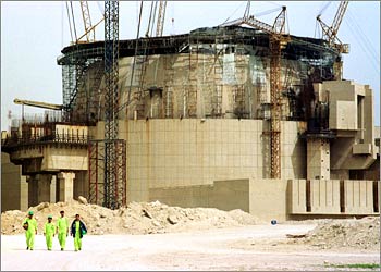Workmen wearing protective clothing walk away from the Russian-built Bushehr nuclear power reactor under construction in southwestern Iran during an organised media visit to the plant on March 11, 2003. Officials told journalists that the plant, which Washington fears is part of a programme to build nuclear weapons, would receive its first shipment of enriched uranium from Russia in May. The 1000 MW plant is due to become operational in the second half of 2004. Iran denies any intention of building nuclear weapons but the United States on March 11 urged Iran to accept tighter inspections by the International Atomic Energy Agency. REUTERS/Morteza Nikoubazl