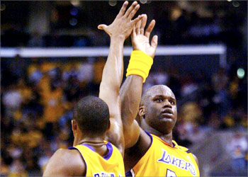 Los Angeles Lakers Kobe Bryant (L) and Shaquille O'Neal high five after O'Neal scored against the Minnesota Timberwolves in third quarter action 01 May 2003 at the Staples Center in Los Angeles in Game 6 of the Western Conference Quarterfinal play-offs. The Lakers defeated the Timberwolves 101-85 to win the series. AFP PHOTO/Lee CELANO