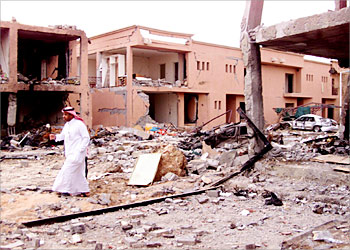 R_A Saudi security man walks in front of a damaged building after a suicide attack on a compound used by expatriates in Riyadh May 13, 2003. Suicide bombers in the Saudi capital killed some 91 people, the U.S. vice president said on Tuesday, making the attack on expatriate housing compounds one of the biggest suspected al Qaeda strikes on Western targets. REUTERS/ STR