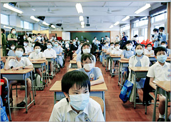 Primary school children wearing masks to ward off the SARS virus attend their first lesson after a six-week school suspension in Hong Kong May 12, 2003. Some 250,000 school children in Hong Kong returned to classes on Monday after the suspension in a bid to contain the killer virus, amid signs the outbreak in the territory was gradually coming under control. REUTERS/Bobby Yip