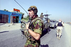 R_International Security Assistance Force (ISAF) personnel stand guard at an explosion site in Kabul, June 7, 2003. Afghan police said five German peacekeepers were killed in an explosion on a bus in the Afghan capital on Saturday, although a spokeswoman for the peacekeeping force said she could only confirm one death. REUTERS/Arko Datta