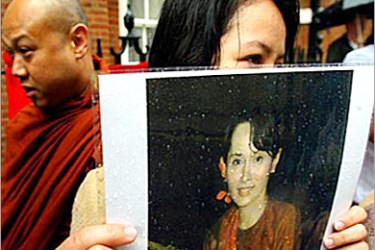 afp - A woman holds a picture of Myanmar's opposition leader Aung San Suu Kyi during demontrations 06 June 2003 by supporters of the United Kingdom-based Free Burma Coalition