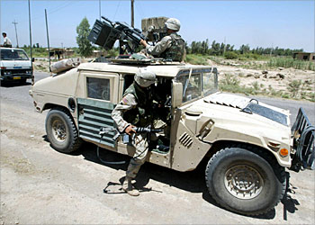 F_A US soldier climbs into a Humvee during a patrol along a road near the town of Balad, north of Baghdad, 27 June 2003. Two US soldiers from 3rd Infantry Division were believed to have gone missing June 25, in a remote location around 40 kilometres (25 miles) south of Balad. The US military intelligence believes toppled leader Saddam Hussein's Fedayeen (guerillas) militia abducted them with their Humvee light armoured vehicle. AFP PHOTO/Ahmad AL-RUBAYE