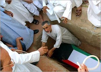 f: Relatives of Kuwaiti prisoner of war (POW) Ahmad al-Qalaf, whose remains have been found in a mass grave in southern Iraq, bury his coffin in Kuwait City 15 June 2003. The remains of al-Qalaf, a Kuwaiti prisoner of war (POW) who disappeared from the emirate during Baghdad's occupation 1990-1991, were found in a grave near Samawa, 200 kilometres (120 miles) south of Baghdad, yesterday.