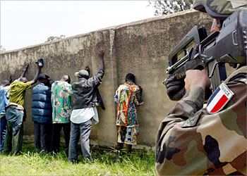 R_A French soldier guards a group of gunmen in the Congolese town of Bunia after confiscating several weapons from them, June 26 2003. A ban on carrying guns imposed by French troops in the Congolese town of Bunia has kindled hopes among locals desperate for an end to violence, but they still feel far from safe. REUTERS / Zohra Bensemra
