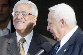 afp - Israeli Prime Minister Ariel Sharon (R) and his Palestinian counterpart Mahmud Abbas smile