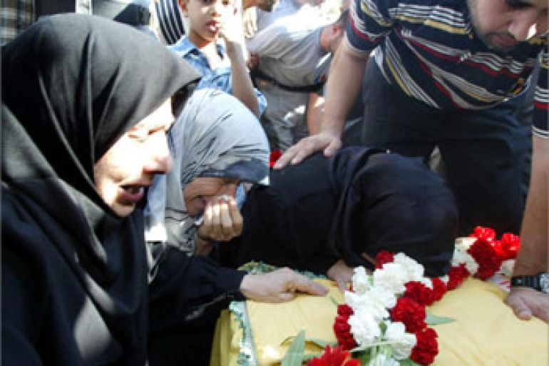 The mother and sisters of Hezbollah activist Ammar Hammoud weep over his coffin during his funeral following the repatriation of two bodies of Lebanese Shiite Muslim Hezbollah fighters by Israel 25 August 2003 in the Lebanese southern port of Naqoura, near the border with Israel. The bodies were transported in two Lebanese Red Cross ambulances preceded by an International Committee for the Red Cross (ICRC) vehicle, past the Lebanese army checkpoint, to the first Hezbollah position at the seafront road near the border.