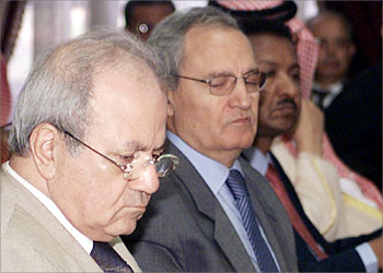 Syria's Foreign affairs minister Farouq al-Shara (C) peers at the Palestinian Liberation Organisation (PLO) official in charge of political affairs Farouk Qadoumi (L) before the start of an Arab League meeting in Cairo August 5, 2003. Arab Foreign ministers will meet to discuss the future of Iraq and the Israeli-Palestinian peace efforts. REUTERS/Aladin Abdel Naby