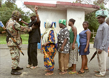 Liberians arriving at the check point near Po River, some 15 km west of Monrovia, from the rebel controlled area , are searched by a Nigerian peacekeeper, August 18,2003. Liberia's government and rebels could be close to signing a peace deal on Monday that would set up an interim administration designed to halt a 14-year spiral of violence, officials said . REUTERS/Vasily Fedosenko